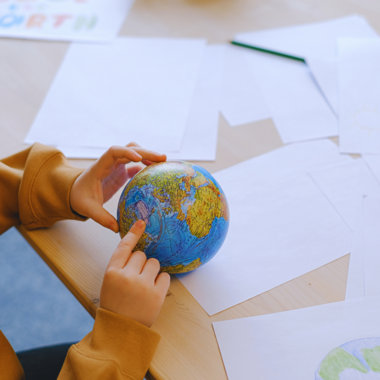 A child exploring a globe at a table